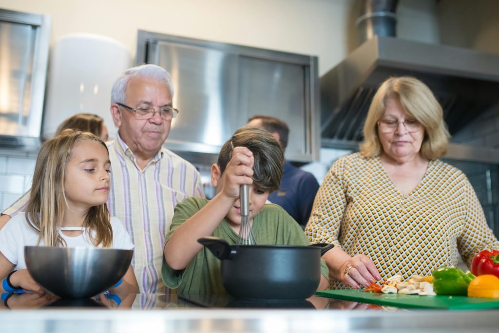 Unos abuelos preparan una receta con sus nietos.