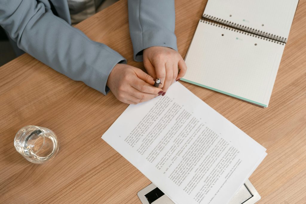 Manos sobre un documento que espera a ser firmado.