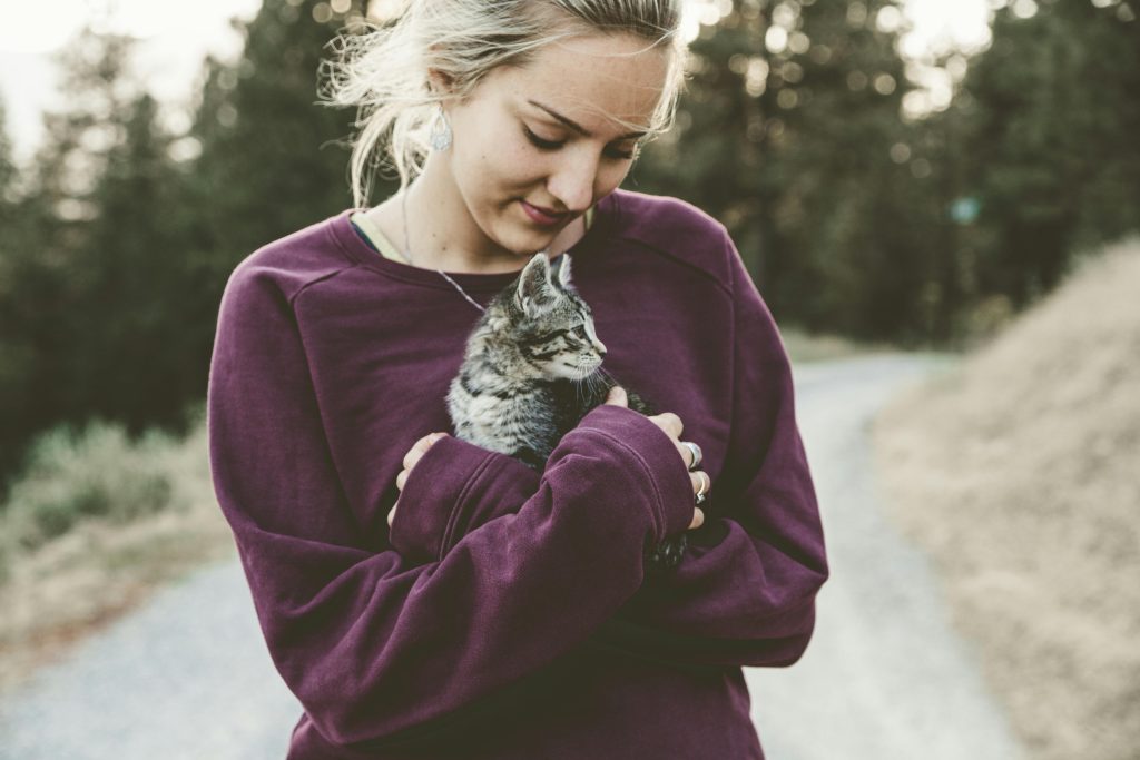 Chica sostiene a un gato en brazos